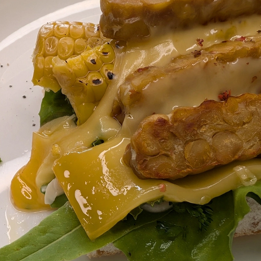 Kichererbsen-Tempeh-Sandwich mit Mais & geschmolzenem Käse